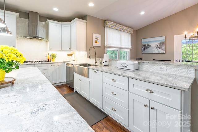 1868 Chestnut Hill Dr, Tega Cay, SC 29708 - kitchen with wall chimney range hood, a sink, stainless steel appliances, a peninsula, and dark wood finished floors