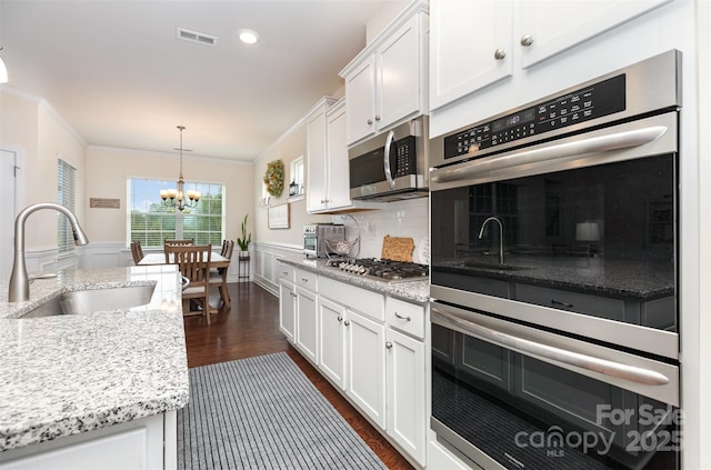 1663 Tranquility Blvd, Lancaster, SC 29720 - kitchen featuring a sink, appliances with stainless steel finishes, a chandelier, white cabinets, and dark wood-style flooring