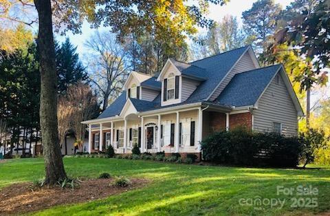 390 Robinson Rd, Mooresville, NC 28117 - cape cod-style house with a front yard and covered porch