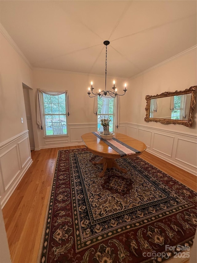 390 Robinson Rd, Mooresville, NC 28117 - dining space featuring light wood-style floors, a chandelier, crown molding, a decorative wall, and a wainscoted wall