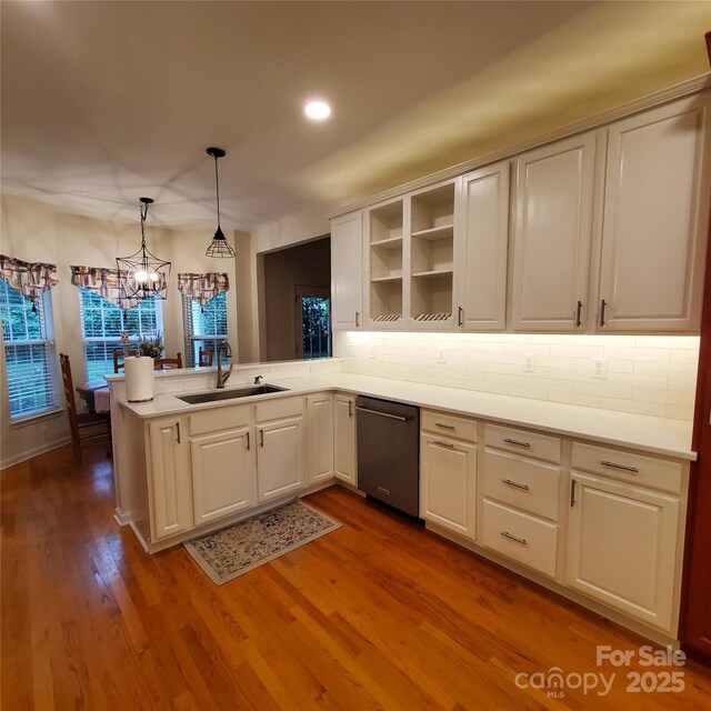 390 Robinson Rd, Mooresville, NC 28117 - kitchen featuring dishwashing machine, a sink, a peninsula, tasteful backsplash, and wood finished floors