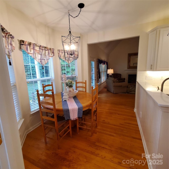 390 Robinson Rd, Mooresville, NC 28117 - dining space with light wood-style floors, a chandelier, a fireplace, and french doors