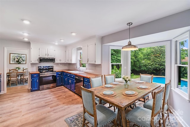 16512 Kimbolten Dr, Huntersville, NC 28078 - kitchen with stainless steel appliances, blue cabinets, wood counters, white cabinetry, and a sink