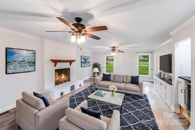 16512 Kimbolten Dr, Huntersville, NC 28078 - living area featuring light wood-style flooring, a fireplace, crown molding, ceiling fan, and baseboards