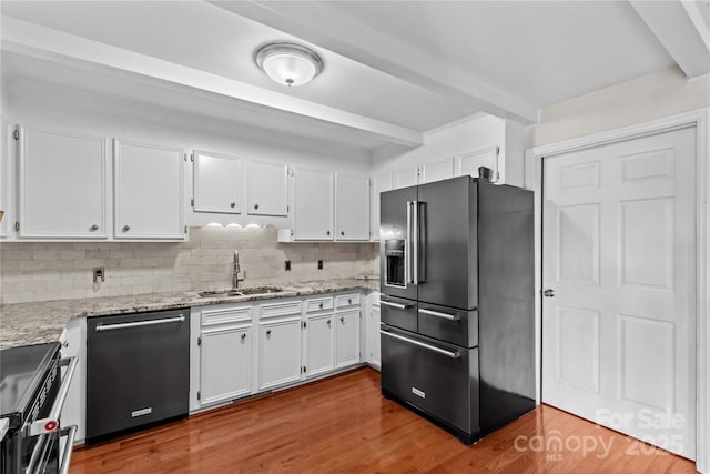 296 Hicks Creek Rd, Troutman, NC 28166 - kitchen featuring appliances with stainless steel finishes, beam ceiling, a sink, white cabinetry, and decorative backsplash