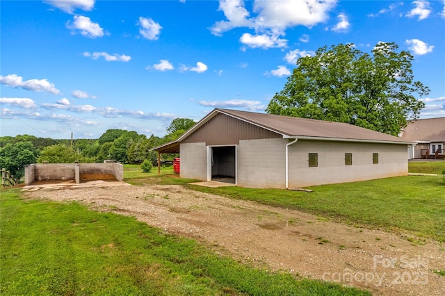 296 Hicks Creek Rd, Troutman, NC 28166 - view of property exterior with concrete block siding, a detached garage, an outbuilding, a yard, and metal roof