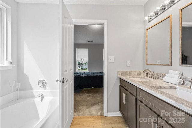13528 Philip Michael Rd, Huntersville, NC 28078 - ensuite bathroom featuring double vanity, wood finished floors, and a tub