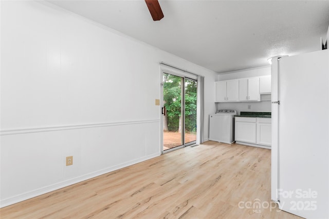 2328 Danforth Ln, Charlotte, NC 28208 - kitchen with washer / clothes dryer, freestanding refrigerator, white cabinetry, light wood finished floors, and dark countertops