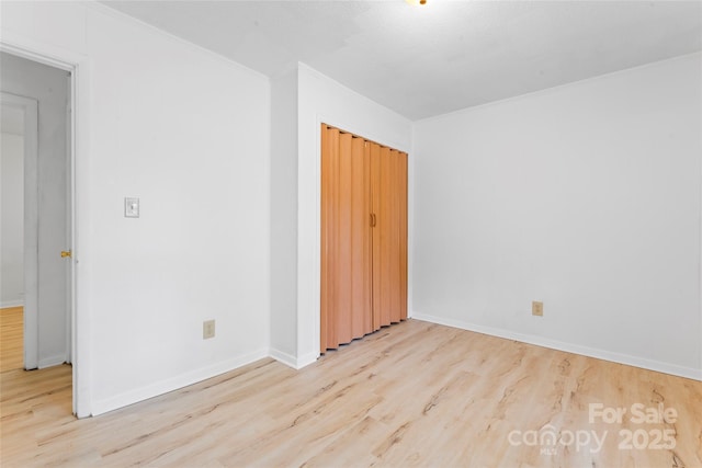 2328 Danforth Ln, Charlotte, NC 28208 - unfurnished bedroom featuring wood finished floors, baseboards, ornamental molding, and a closet