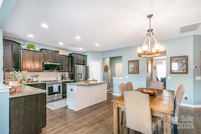 5092 Nighthawk Dr, Indian Land, SC 29707 - kitchen featuring stainless steel appliances, a kitchen island, dark wood-style floors, backsplash, and a chandelier