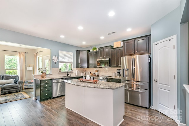 5092 Nighthawk Dr, Indian Land, SC 29707 - kitchen with appliances with stainless steel finishes, light stone counters, decorative backsplash, a center island, and recessed lighting