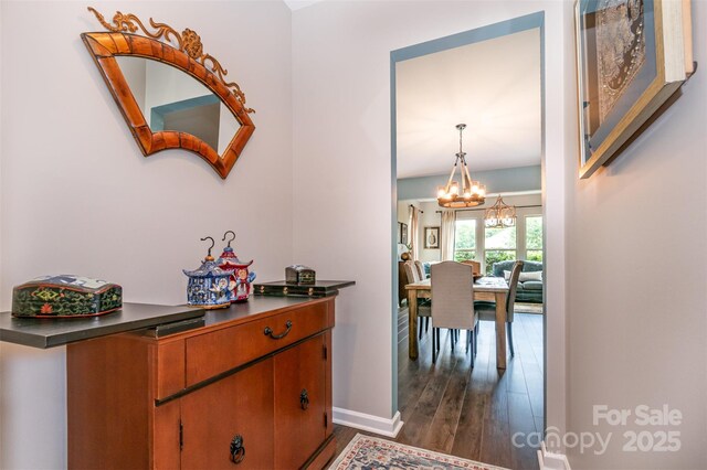 5092 Nighthawk Dr, Indian Land, SC 29707 - hallway featuring a chandelier, dark wood-style floors, and baseboards