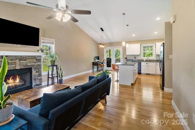 39 Curtis Miles Rd, Alexander, NC 28701 - living room with a fireplace, ceiling fan, baseboards, light wood-style flooring, and lofted ceiling