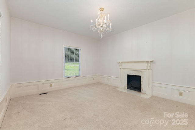 130 Merton Rd, Lawndale, NC 28090 - unfurnished living room featuring a decorative wall, a chandelier, a high end fireplace, carpet floors, and wainscoting