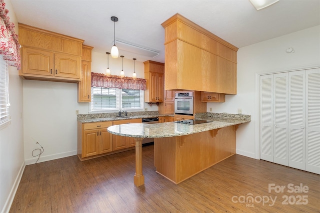 130 Merton Rd, Lawndale, NC 28090 - kitchen featuring appliances with stainless steel finishes, a peninsula, a sink, wood finished floors, and light stone counters