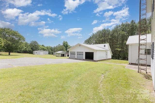 130 Merton Rd, Lawndale, NC 28090 - view of green lawn featuring an outdoor structure, a detached garage, and asphalt driveway