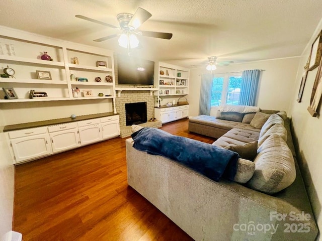 734 Forestbrook Dr, Gastonia, NC 28056 - living room with ceiling fan, dark wood-style floors, a fireplace, and a textured ceiling