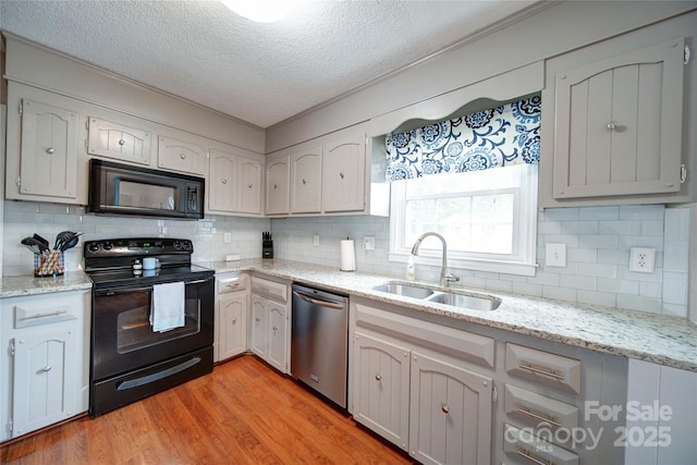 734 Forestbrook Dr, Gastonia, NC 28056 - kitchen featuring black appliances, a textured ceiling, tasteful backsplash, light wood finished floors, and light stone countertops