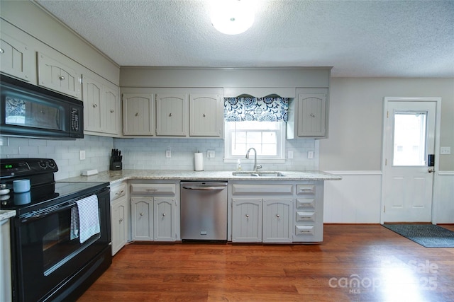 734 Forestbrook Dr, Gastonia, NC 28056 - kitchen with black appliances, a textured ceiling, backsplash, dark wood-style flooring, and a wainscoted wall