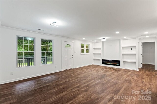 704 W Border St, Dallas, NC 28034 - unfurnished living room with dark wood-style floors, crown molding, baseboards, built in shelves, and a glass covered fireplace
