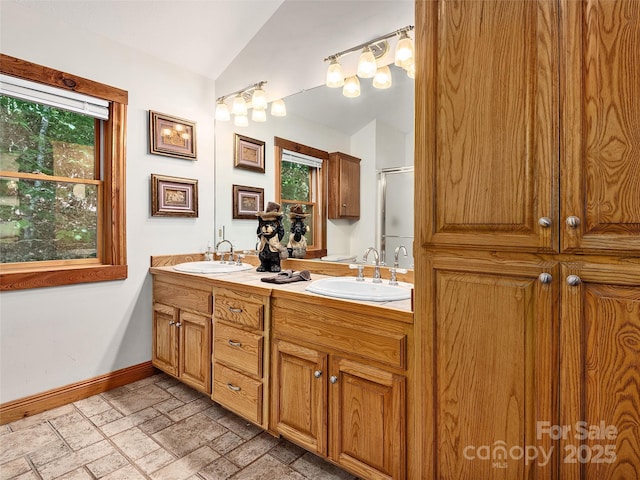 505 Middle Top Loop, Maggie Valley, NC 28751 - bathroom featuring vaulted ceiling, double vanity, baseboards, stone tile floors, and a shower with door