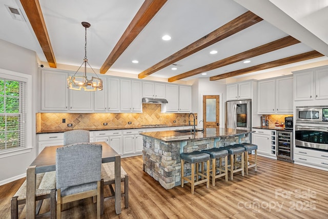1849 Still Water Ln, Indian Land, SC 29707 - kitchen featuring wine cooler, stainless steel appliances, a sink, a kitchen breakfast bar, and a chandelier