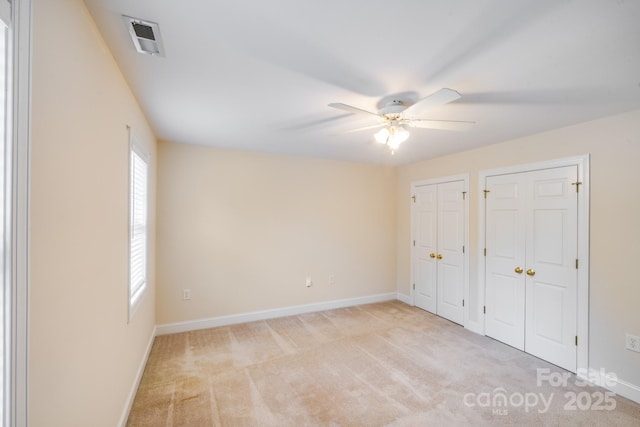 2065 Gable Way Ln, Matthews, NC 28104 - unfurnished bedroom featuring multiple closets, light carpet, and ceiling fan