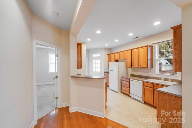 2065 Gable Way Ln, Matthews, NC 28104 - kitchen with white appliances, plenty of natural light, recessed lighting, a peninsula, and light wood finished floors