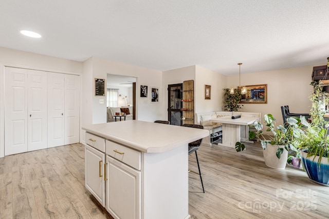 101 Michael Ct, Leicester, NC 28748 - kitchen featuring light wood-style floors, a kitchen breakfast bar, light countertops, a kitchen island, and white cabinetry