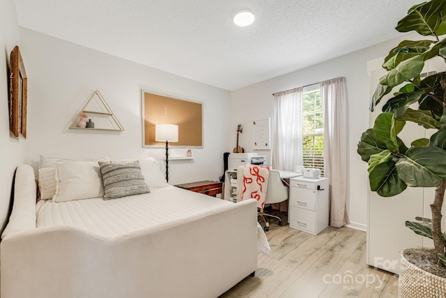 101 Michael Ct, Leicester, NC 28748 - bedroom featuring light wood finished floors, a textured ceiling, baseboards, and a desk