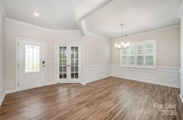 150 Haddonsfield Dr, Mooresville, NC 28115 - foyer entrance with wood finished floors, french doors, a chandelier, a wainscoted wall, and ornamental molding