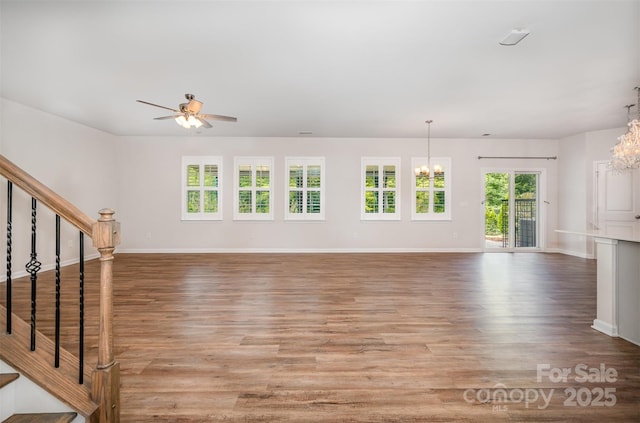 150 Haddonsfield Dr, Mooresville, NC 28115 - unfurnished living room with a chandelier, a ceiling fan, stairs, and wood finished floors