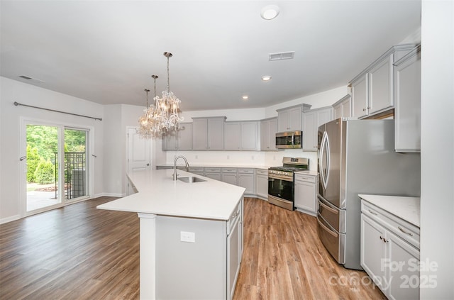 150 Haddonsfield Dr, Mooresville, NC 28115 - kitchen with stainless steel appliances, a sink, gray cabinetry, light countertops, and light wood-type flooring