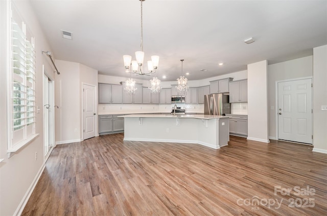 150 Haddonsfield Dr, Mooresville, NC 28115 - kitchen with gray cabinetry, stainless steel appliances, a chandelier, a sink, and light countertops