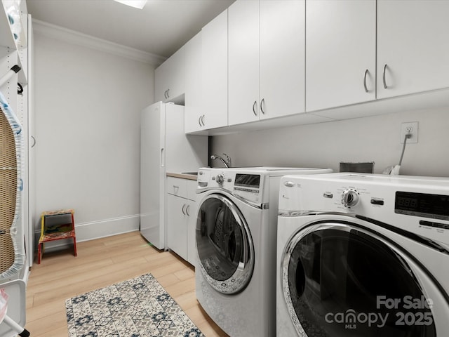 315 Mountainview Dr, Charlotte, NC 28270 - laundry area featuring cabinet space, crown molding, light wood-style floors, independent washer and dryer, and baseboards
