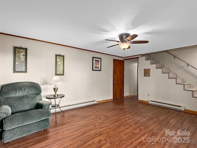 573 Valeria Ln, Pisgah Forest, NC 28768 - sitting room with a baseboard radiator, baseboard heating, wood finished floors, ceiling fan, and stairway