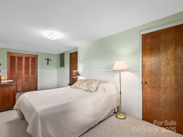 573 Valeria Ln, Pisgah Forest, NC 28768 - bedroom with a wainscoted wall, a closet, carpet, and a textured ceiling