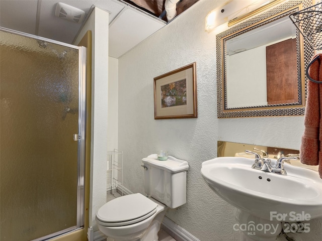 573 Valeria Ln, Pisgah Forest, NC 28768 - bathroom with a textured wall, a stall shower, toilet, baseboards, and a sink