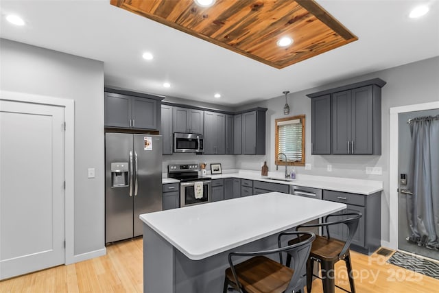 358 London Rd, Asheville, NC 28803 - kitchen featuring stainless steel appliances, a sink, a kitchen bar, a kitchen island, and light countertops
