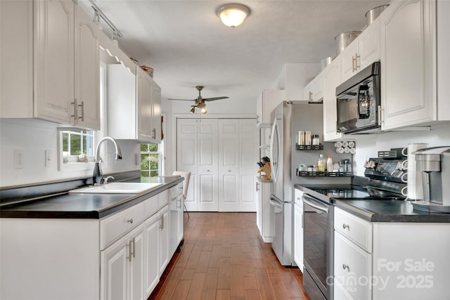 186 Hawks Point Dr, Zirconia, NC 28790 - kitchen with stainless steel range with electric cooktop, black microwave, ceiling fan, dark countertops, and dark wood-style floors