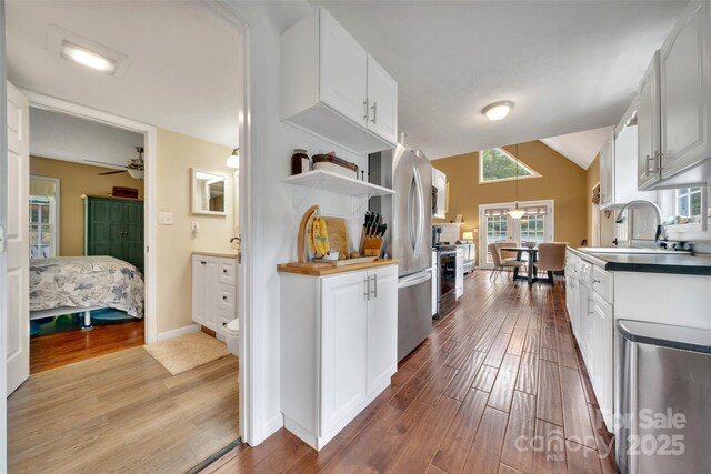 186 Hawks Point Dr, Zirconia, NC 28790 - kitchen with wood finished floors, white cabinetry, a sink, freestanding refrigerator, and baseboards