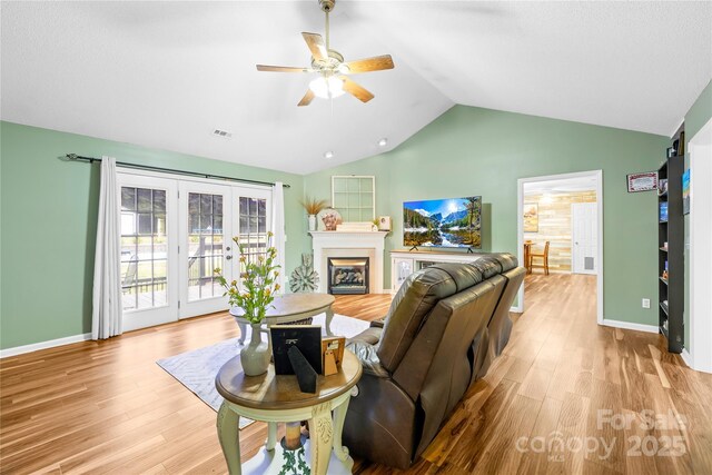 106 Laren Rd, Shelby, NC 28152 - living area with a ceiling fan, wood finished floors, vaulted ceiling, a glass covered fireplace, and french doors