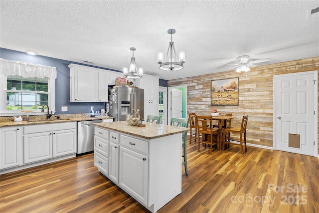 106 Laren Rd, Shelby, NC 28152 - kitchen with stainless steel appliances, wooden walls, a ceiling fan, a textured ceiling, and a chandelier