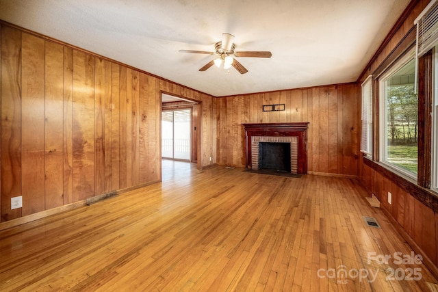 260 Penninger Dr, Woodleaf, NC 27054 - unfurnished living room with ceiling fan, a fireplace, hardwood / wood-style floors, wooden walls, and ornamental molding