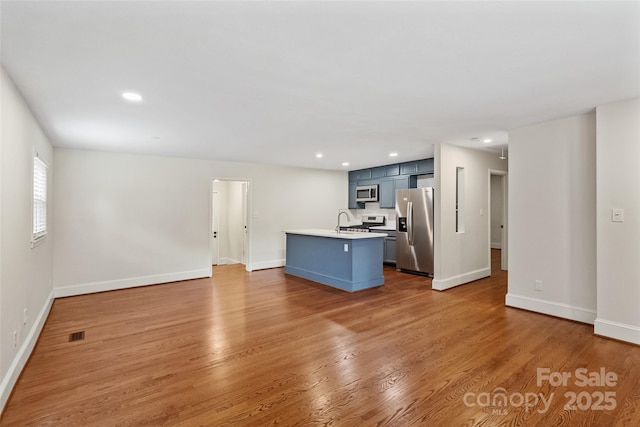 4906 Charleston Dr, Charlotte, NC 28212 - kitchen featuring stainless steel appliances, light countertops, light wood-style flooring, open floor plan, and recessed lighting