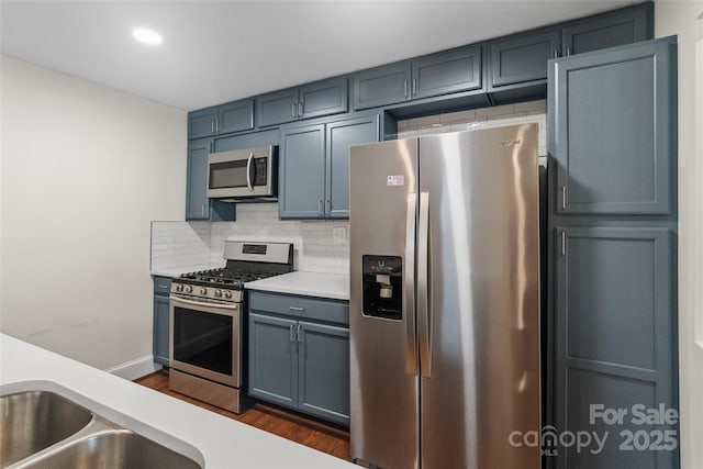 4906 Charleston Dr, Charlotte, NC 28212 - kitchen with stainless steel appliances, light countertops, decorative backsplash, dark wood-type flooring, and recessed lighting