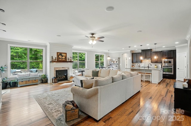 110 St Sophia Ct, Mooresville, NC 28117 - living area featuring ornamental molding, ceiling fan, a glass covered fireplace, light wood-style floors, and recessed lighting