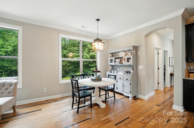 110 St Sophia Ct, Mooresville, NC 28117 - dining room featuring arched walkways, light wood finished floors, ornamental molding, baseboards, and a chandelier