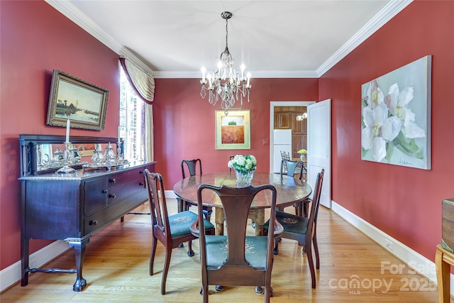 1021 Isleworth Ave, Charlotte, NC 28203 - dining room featuring ornamental molding, a chandelier, baseboards, and light wood-type flooring