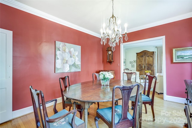 1021 Isleworth Ave, Charlotte, NC 28203 - dining space featuring a chandelier, crown molding, light wood-style floors, and baseboards